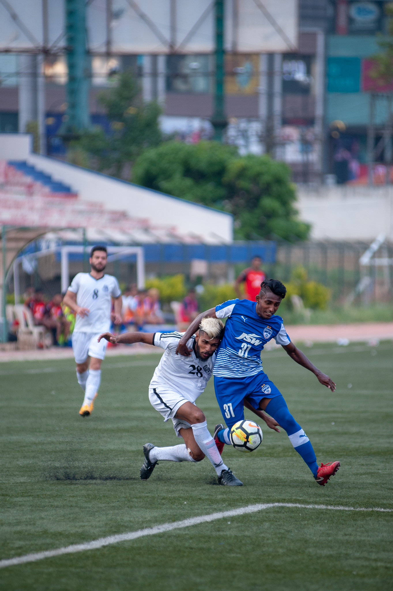 Leon Augustine tussles with a Sporting Mohammedan player for the ball on the right wing before firing in a cross.